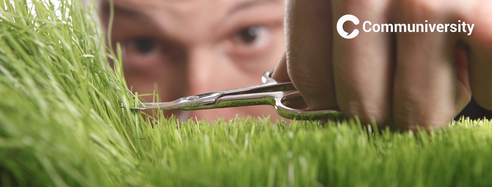 Mann schneidet Gras mit Nagelschere